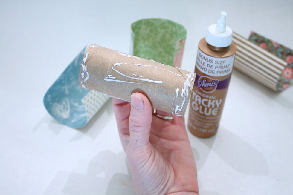 Add some Tacky Glue to the roll- get the ends good. Use glue as it has "play" in it to help you line up your paper just right