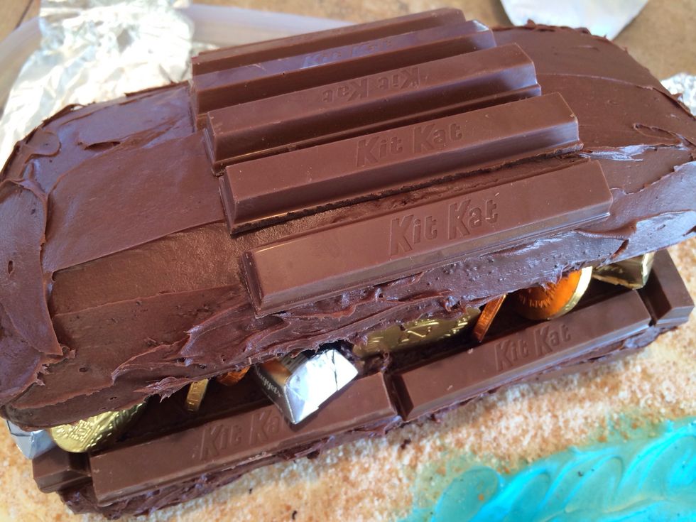 Add some treasure inside. Place a row of centered Kit Kats on the lid.