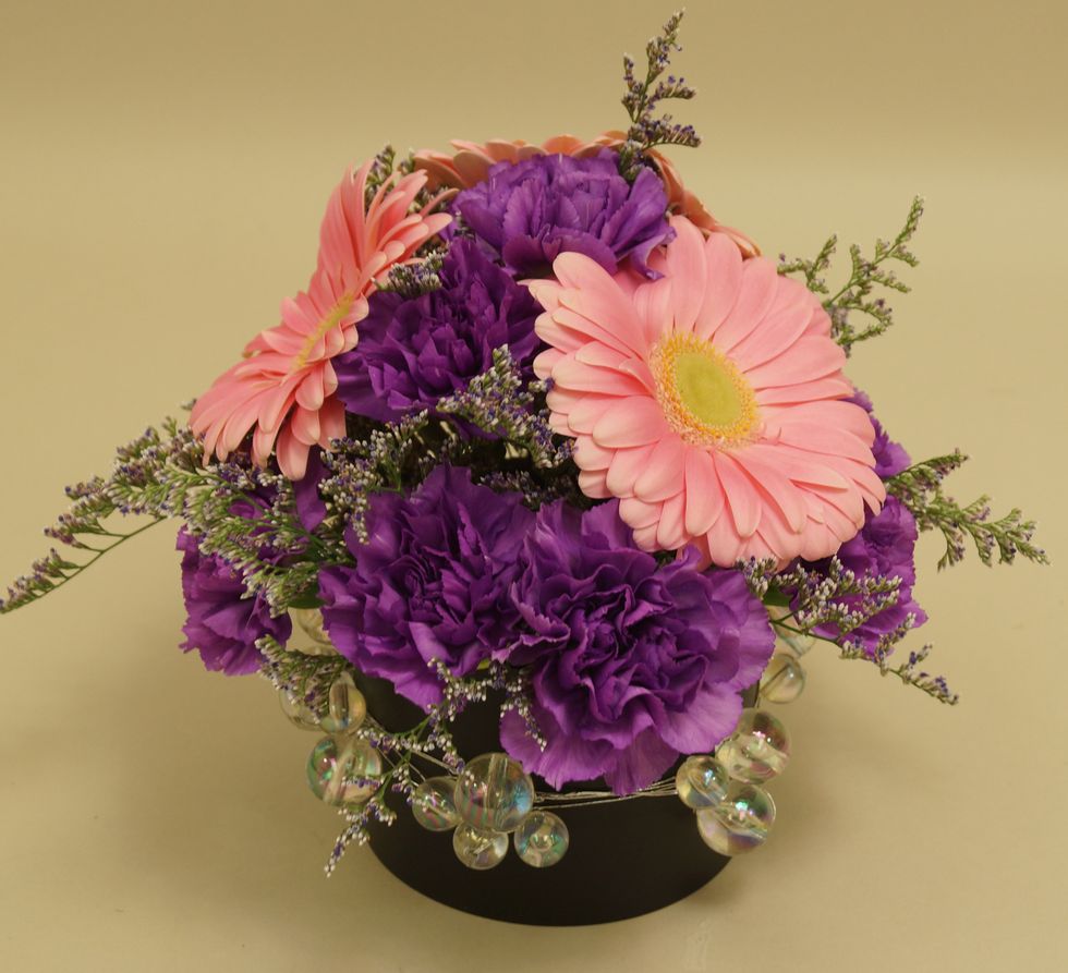 Add stems of pink gerberas into foam.