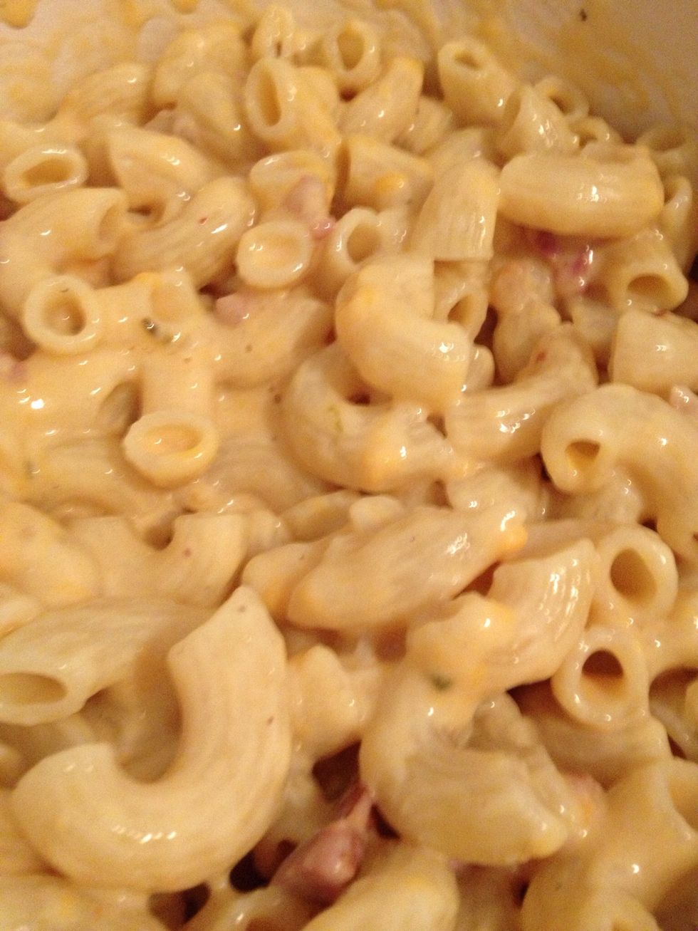 Add strained pasta to cheese sauce in parts, stirring after each addition to ensure each macaroni is coated in cheese. Your flame should be off by now.