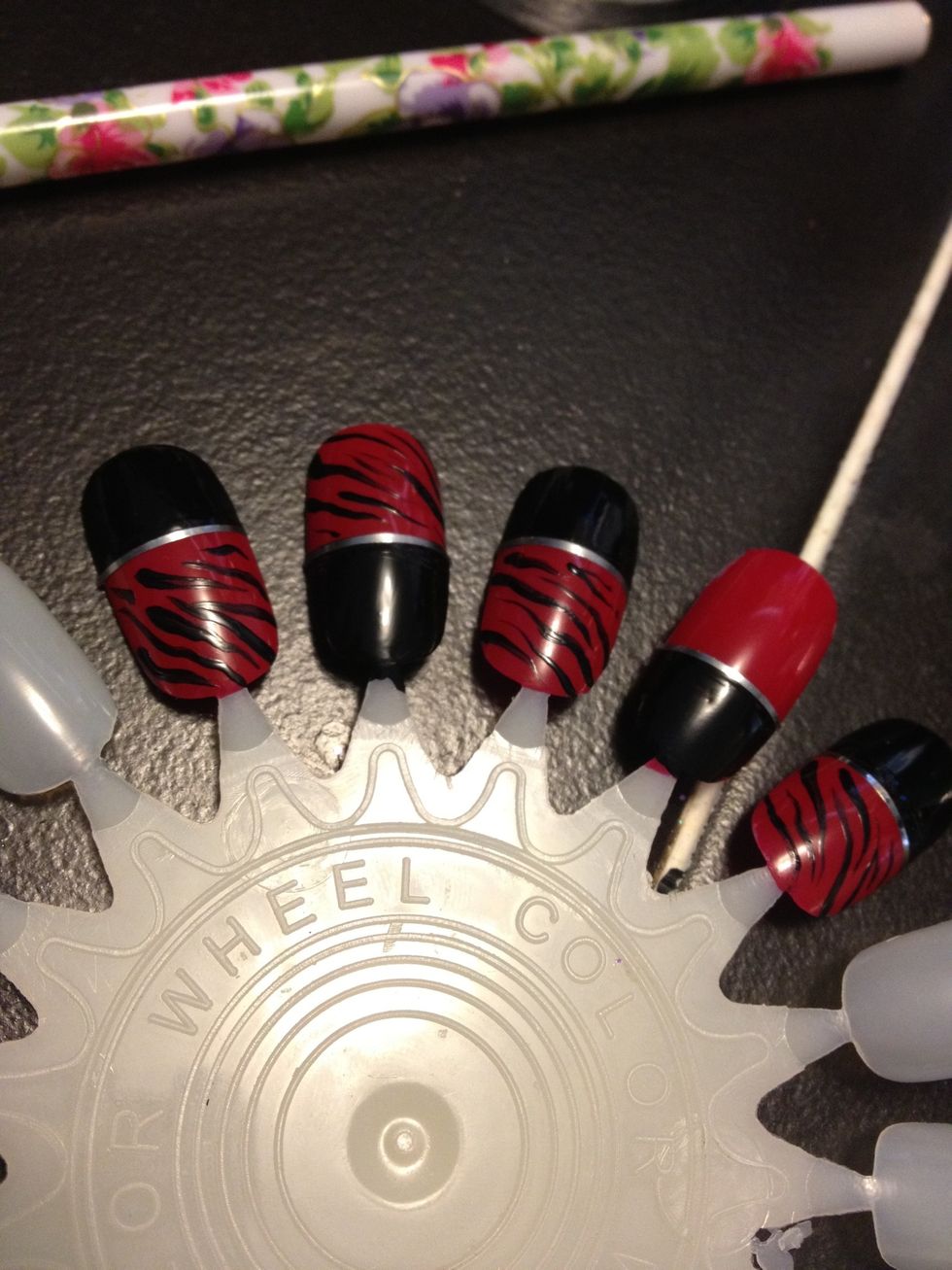 Add stripes on the red area of the nail. Leave one nail alone though.. Preferably the ring finger.