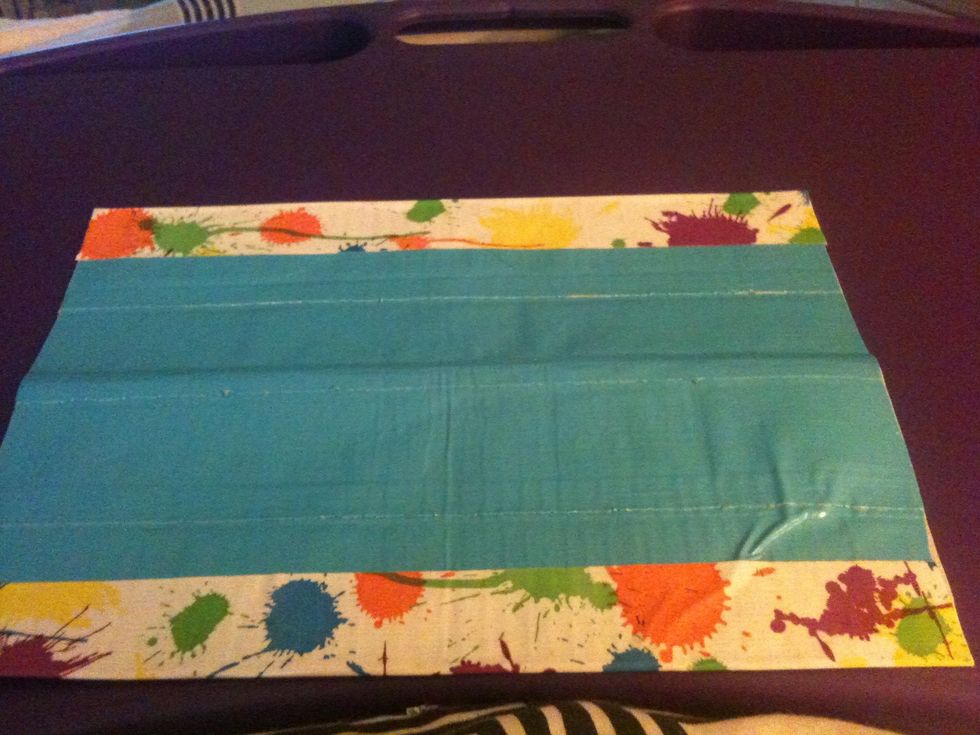 Add strips of duct tape on the long edges. Half should be on the (in this case) blue side and the other on the purple.