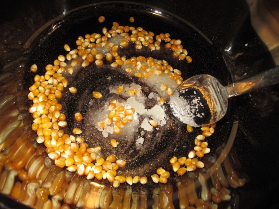 Add sugar and kernels. Stir and then cover.
