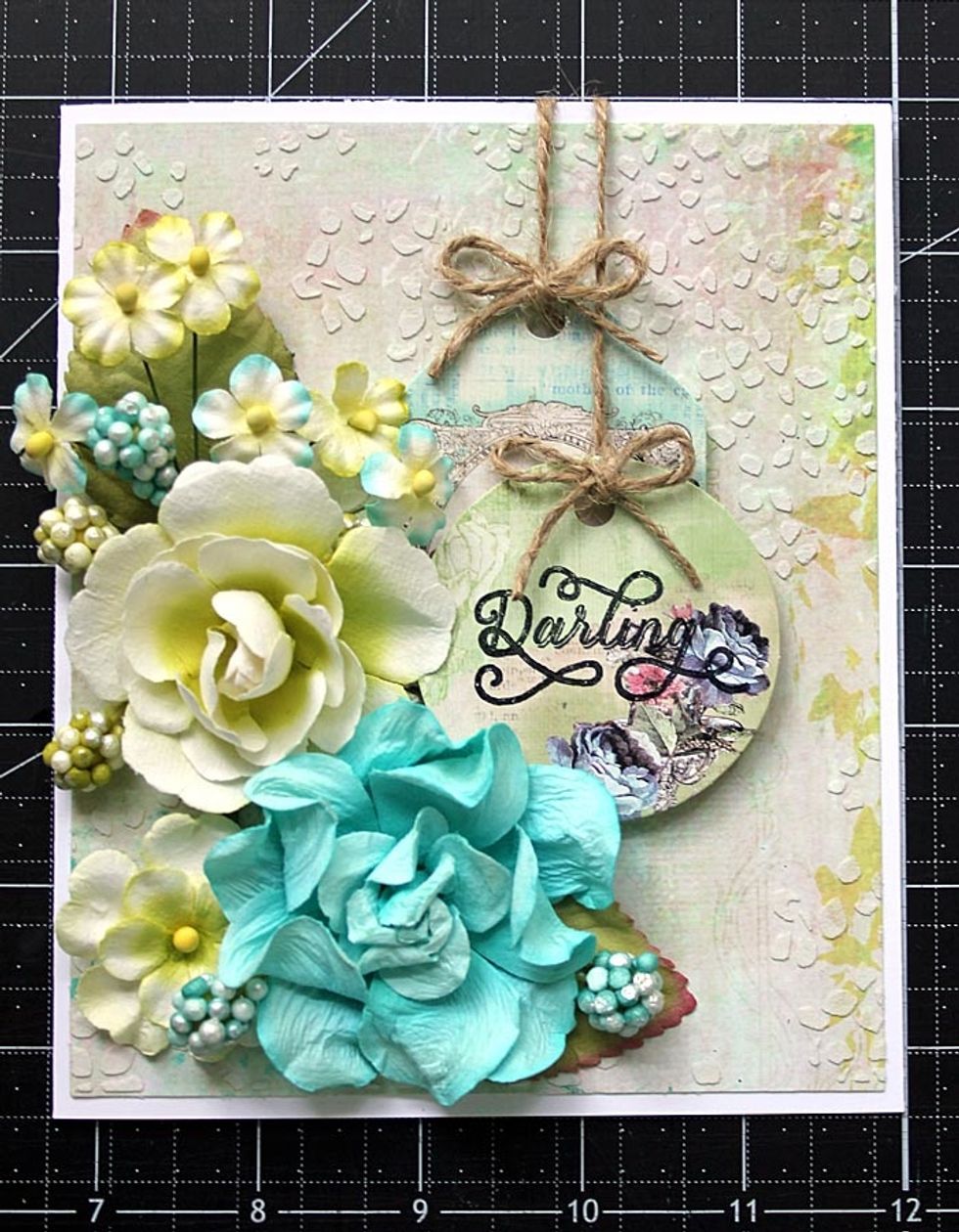 Add tags to the right, center of the card just beside the flower cluster. Tie two bows using the extra twine. Add to the center of each tag.