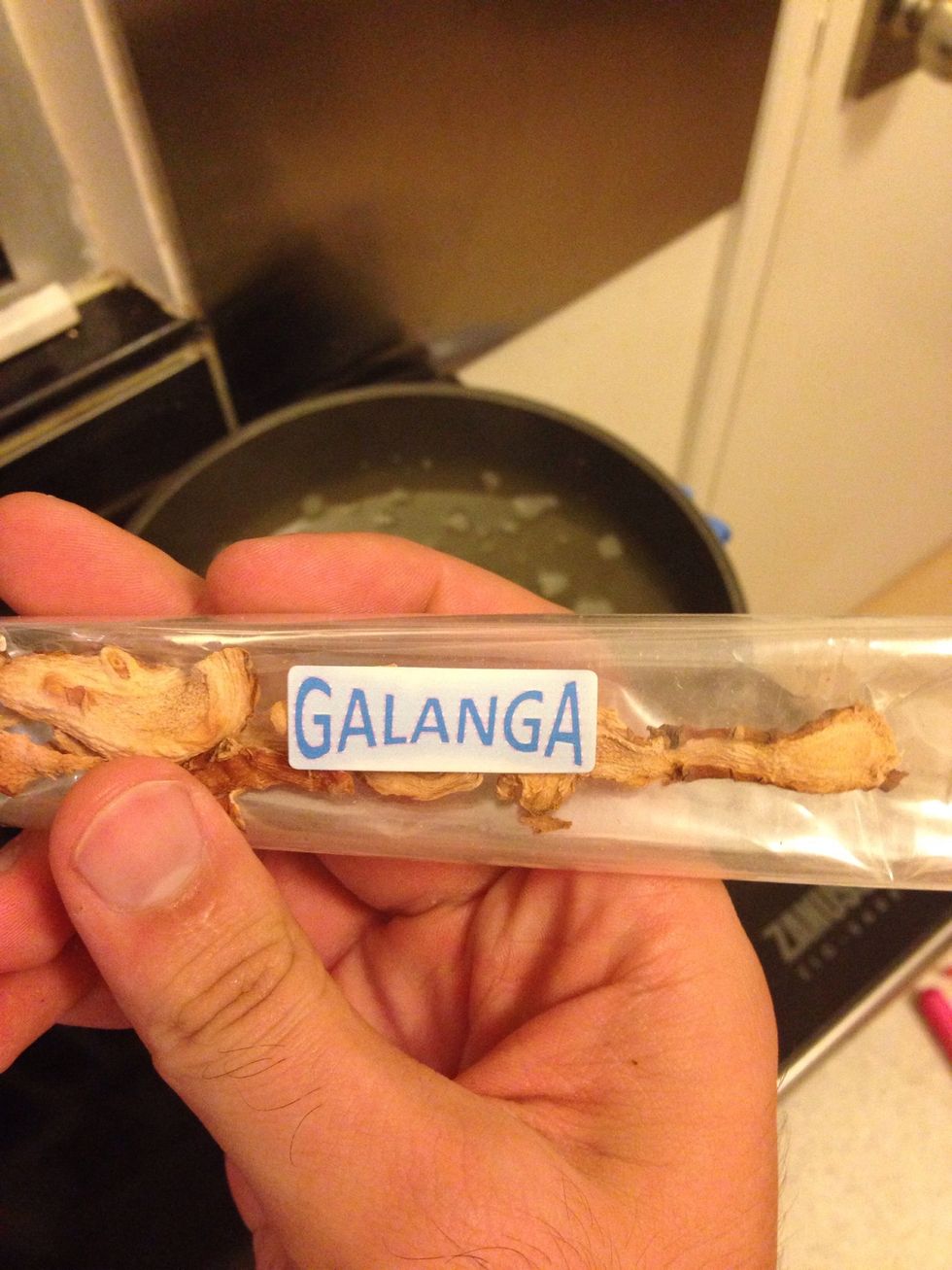 Add Thai galangal. Preferably fresh. Bruise the roots and slice