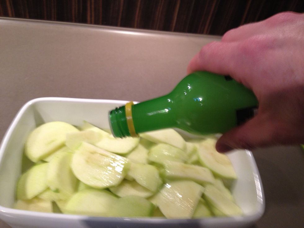 Add the apples to a baking dish, sprinkle with lemon juice and a touch of sugar, then shake gently to ensure the lemon  juice coats the apple pieces.