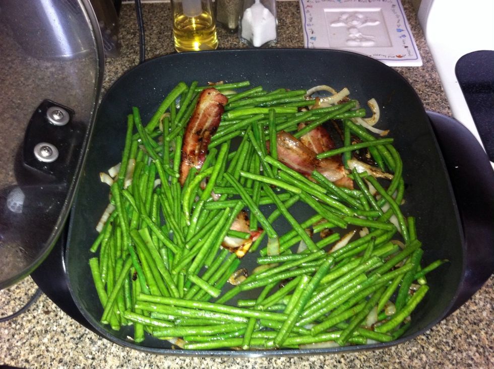 Add the beans to the skillet, and saut\u00e9 with the onions and bacon for about 10 minutes on medium heat.