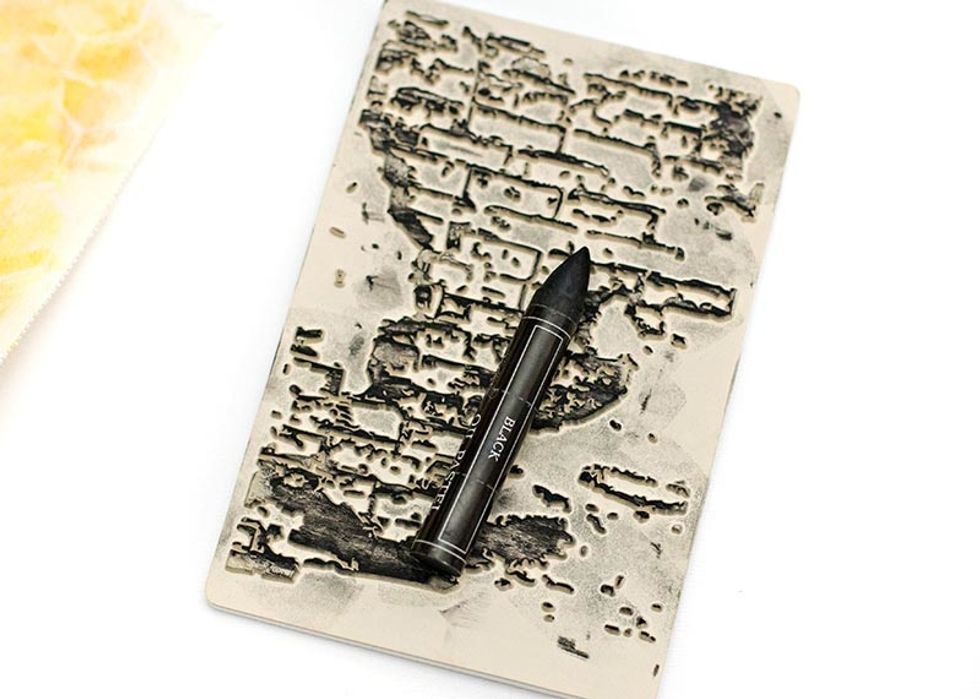 Add the black Oil Pastel straight on a background stamp. Spray a little water on to the stamp to activate the color, then stamp directly on the canvas. This creates a really nice watercolor image.