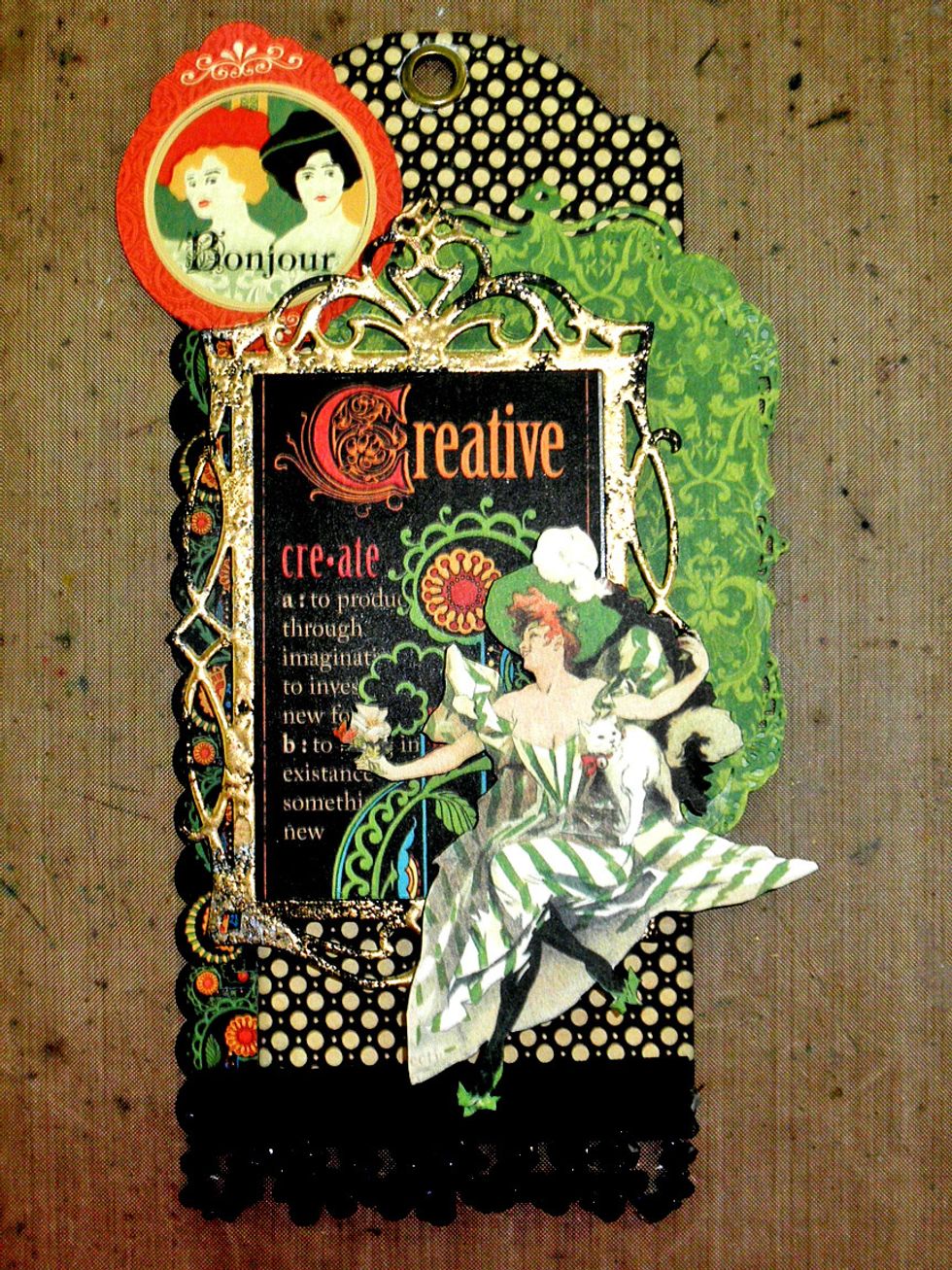 Add the Bonjour sticker to the top as shown.  I added a round diecut frame behind it in the next step.  Add the fussy cut lady at the bottom using foam tape to pop her up.