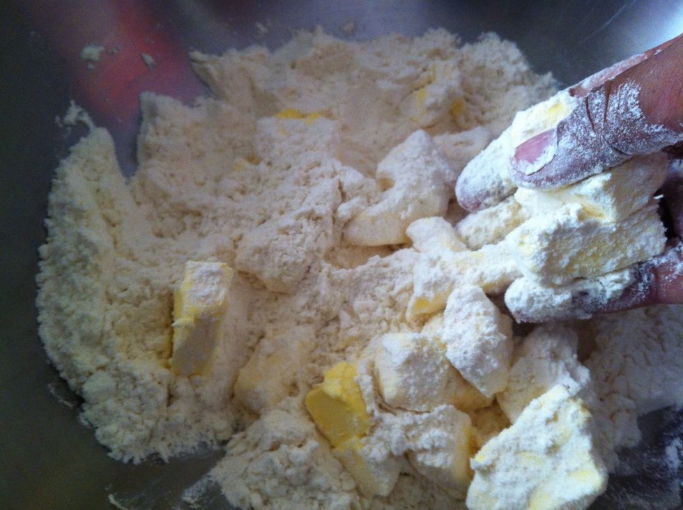 Add the butter and break it up roughly with your fingers, making sure to keep visible little chunks of butter in the dough