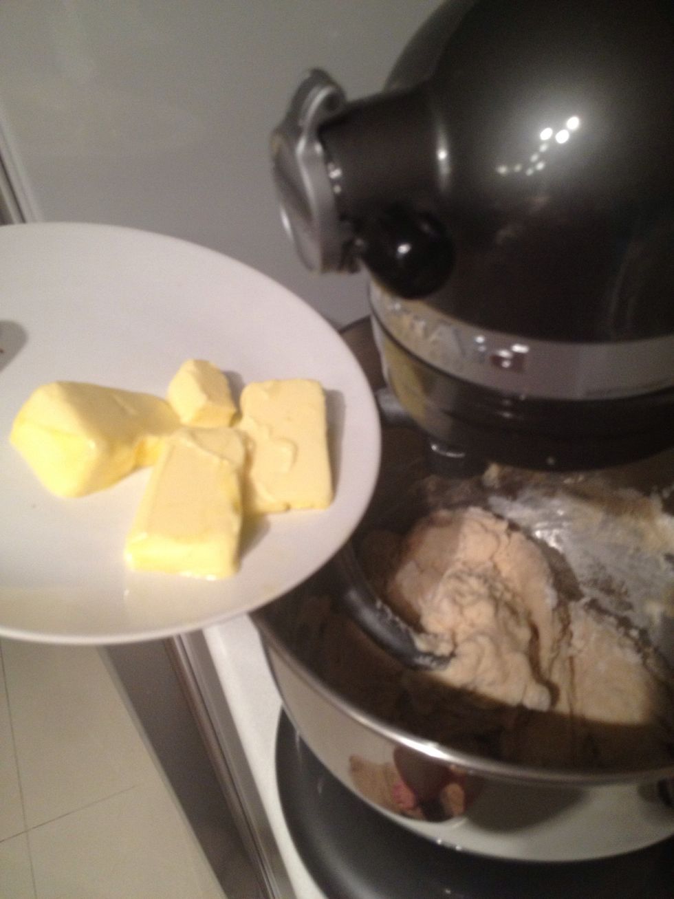 Add the butter and keep the machine running. Scrape the side every once in a while.