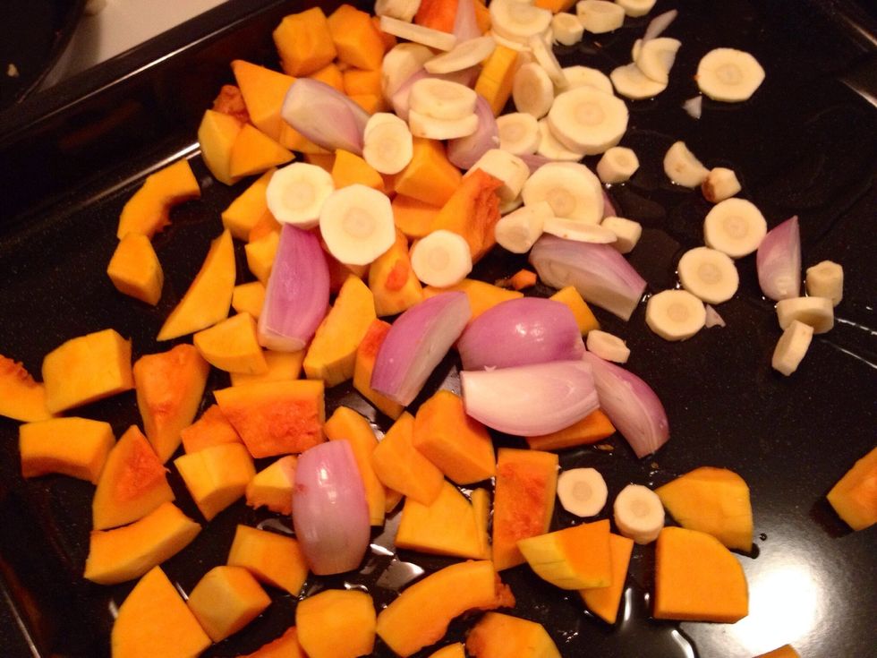 Add the butternut squash, the shallots, the parsnips and the garlic cloves.