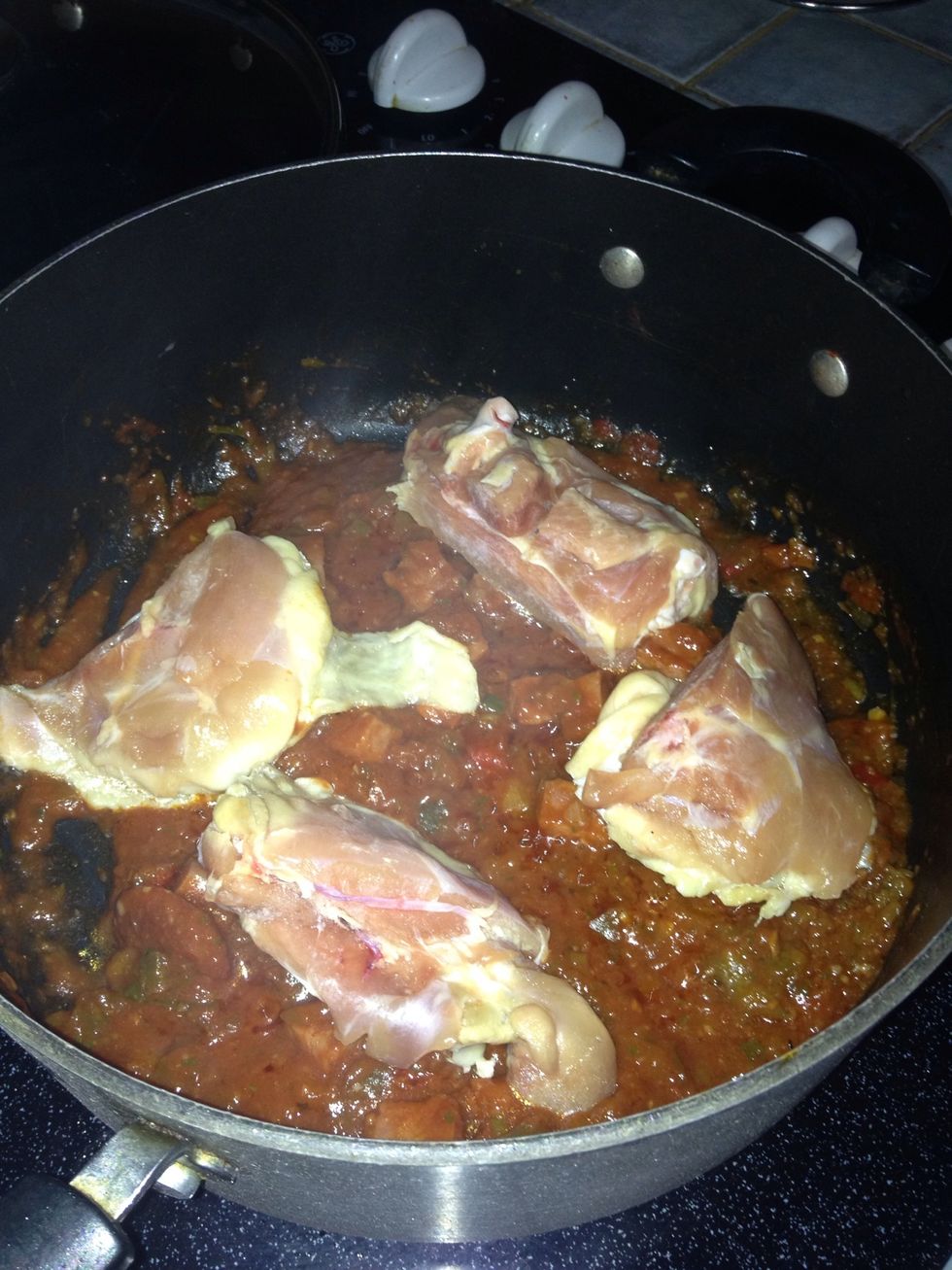 Add the can of tomato sauce and the chicken thighs. Again, stir all the ingredients.