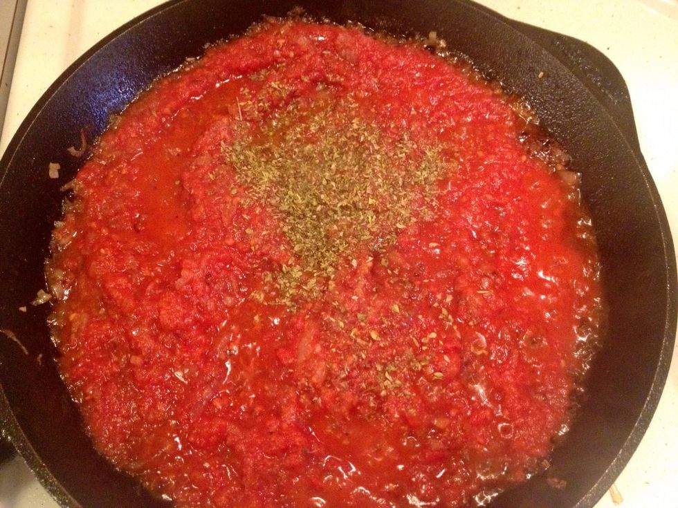 Add the canned tomatoes, oregano, salt, sugar and black pepper.