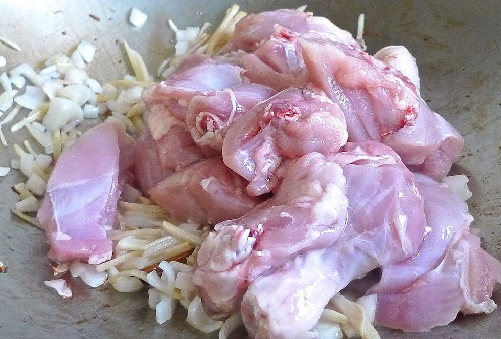 Add the chicken pieces and stir fry till well mixed with the ginger and onions.