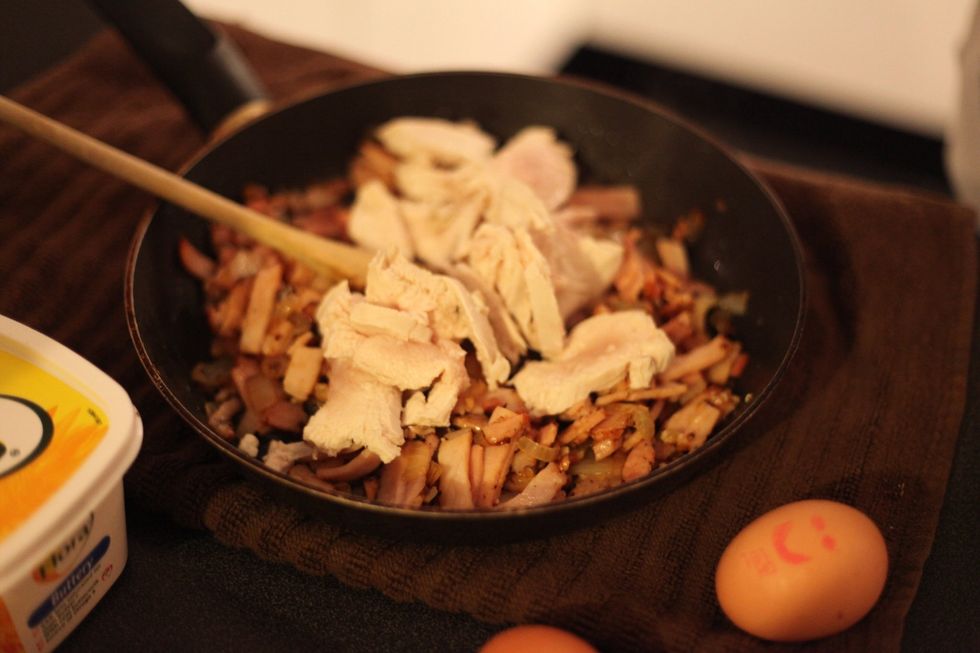 Add the chicken pieces to the bacon and stir, cooking on medium heat.