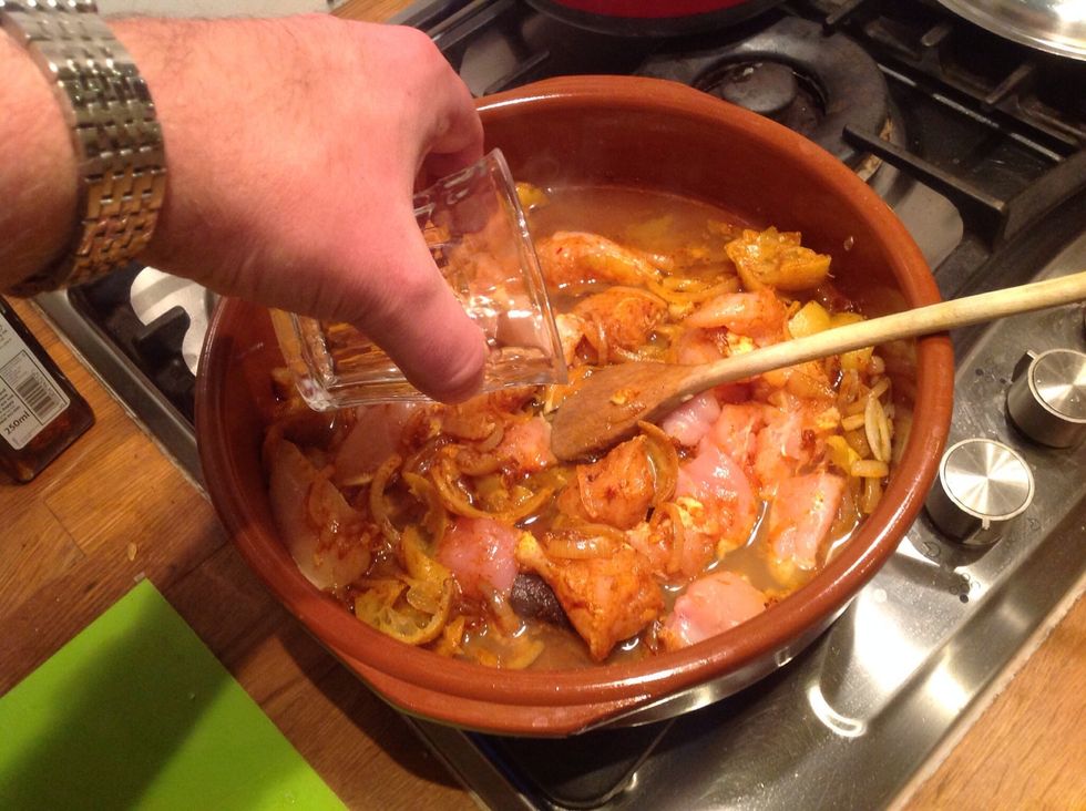 Add the chicken then about a cup of water.  Bring to the boil and then turn down to a gentle simmer, adding in the sliced preserved lemon.  Cover with the Tagine lid if you are using or other lid
