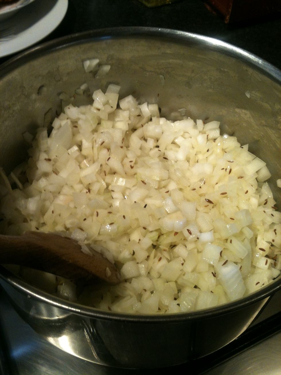 Add the chopped onion to the cumin seeds. Fry on a medium heat till the onion goes a pale gold colour. Again don't burn as it will leave a very bitter taste.