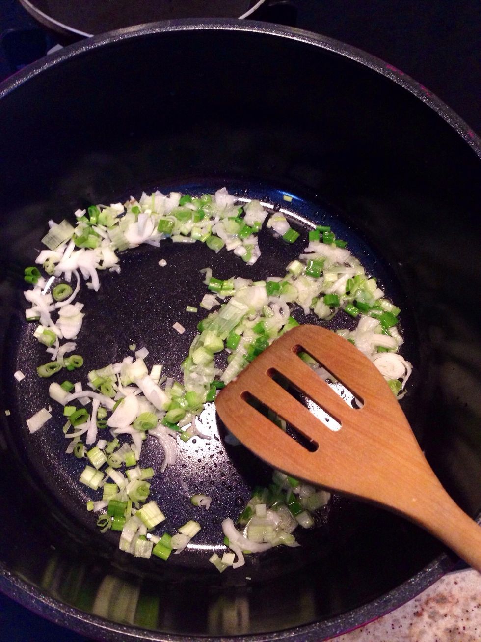 Add the chopped white part of spring onions and saut\u00e9