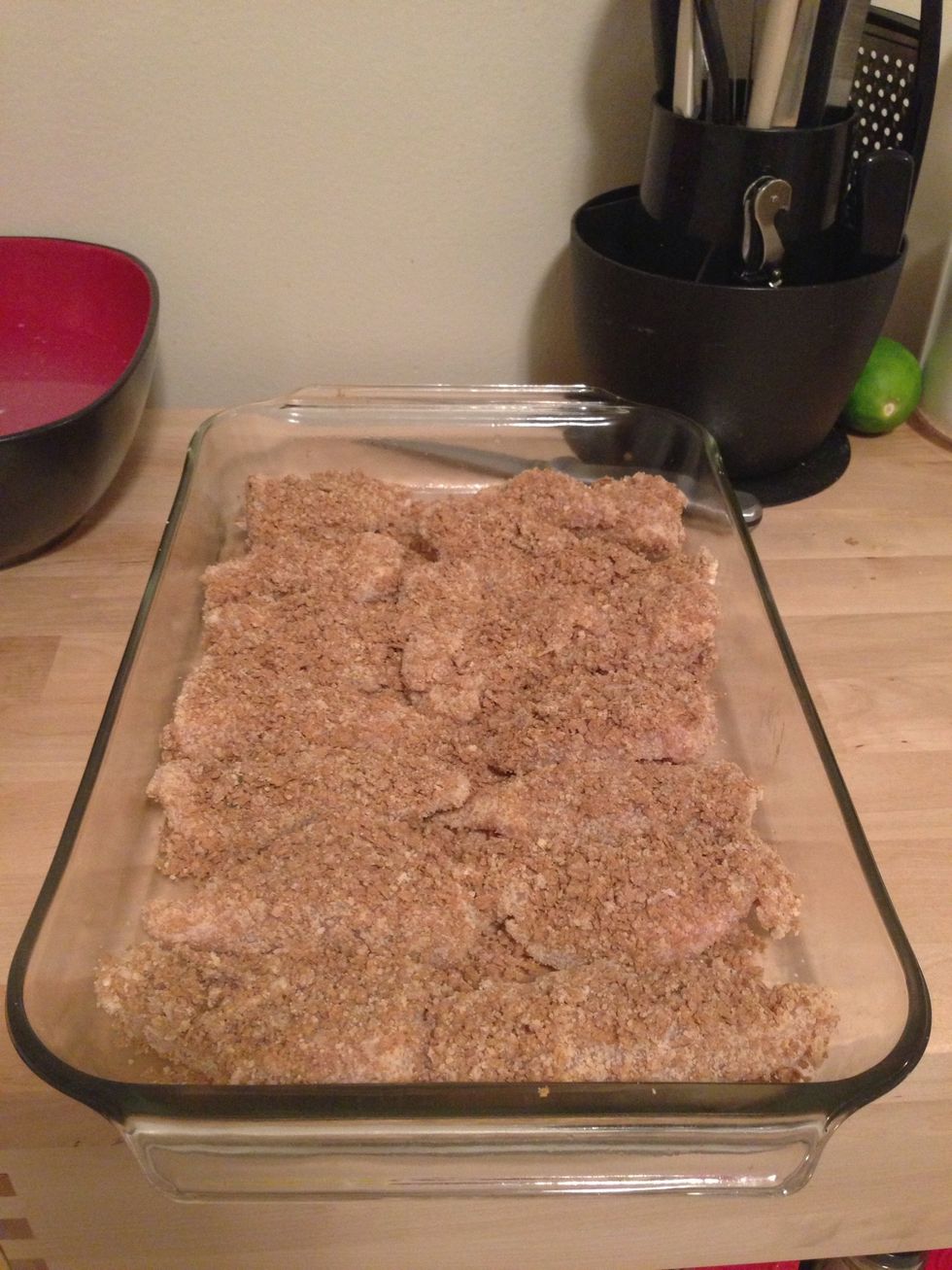 Add the coated chicken to a pan. I also add the extra bran flakes mixture to the top because it tastes amazing crispy.