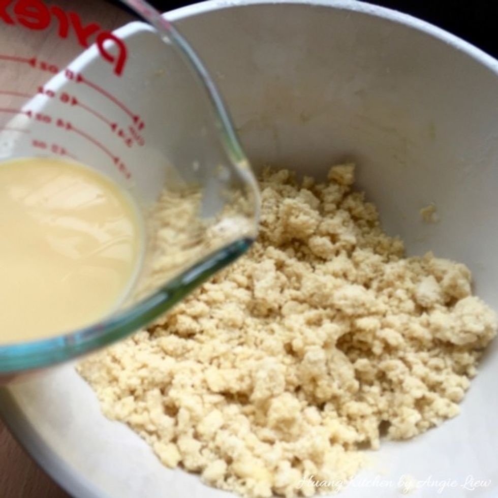 Add the combined egg yolk and cold water into the coarse crumb flour mixture.