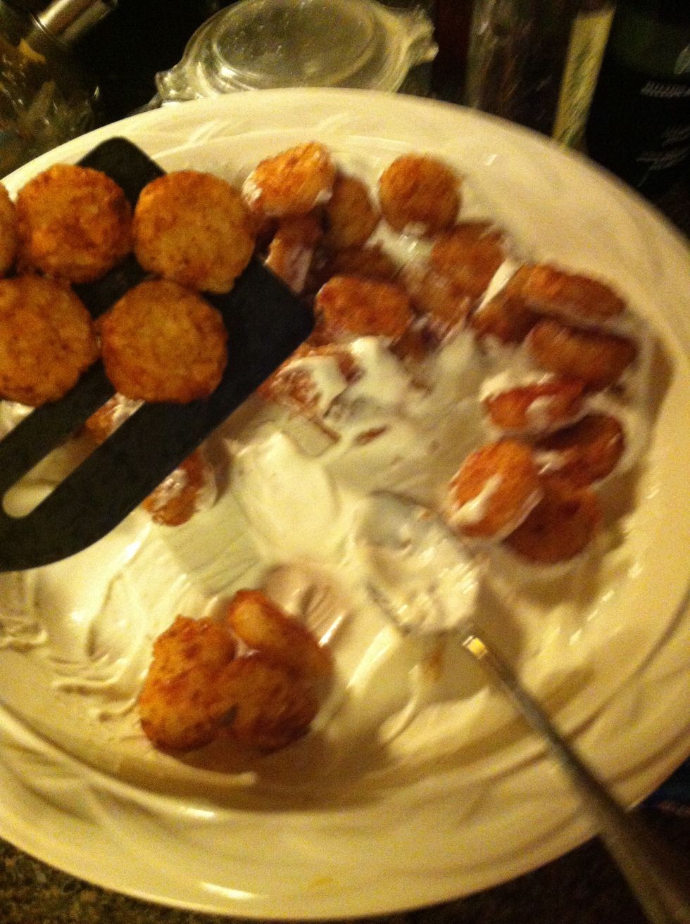 Add the cooked tater tots to the bowl. And coat each one with sour cream