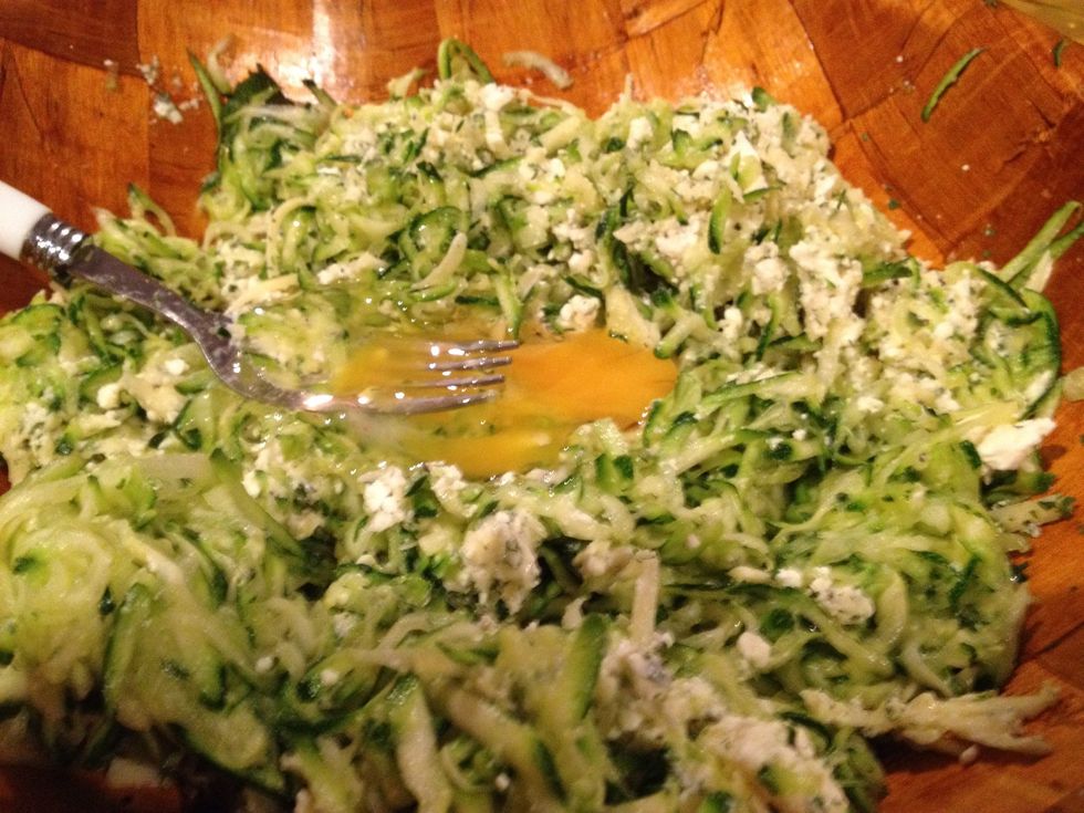 Add the courgettes to your cheese mixture. I forgot the second egg so I'm adding it now. Mix well.