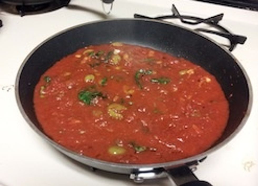 Add the crushed tomatoes into the skillet and cook about 2 minutes. Then add the basil and cook until the sauce thickens, 1 to 2 minutes.