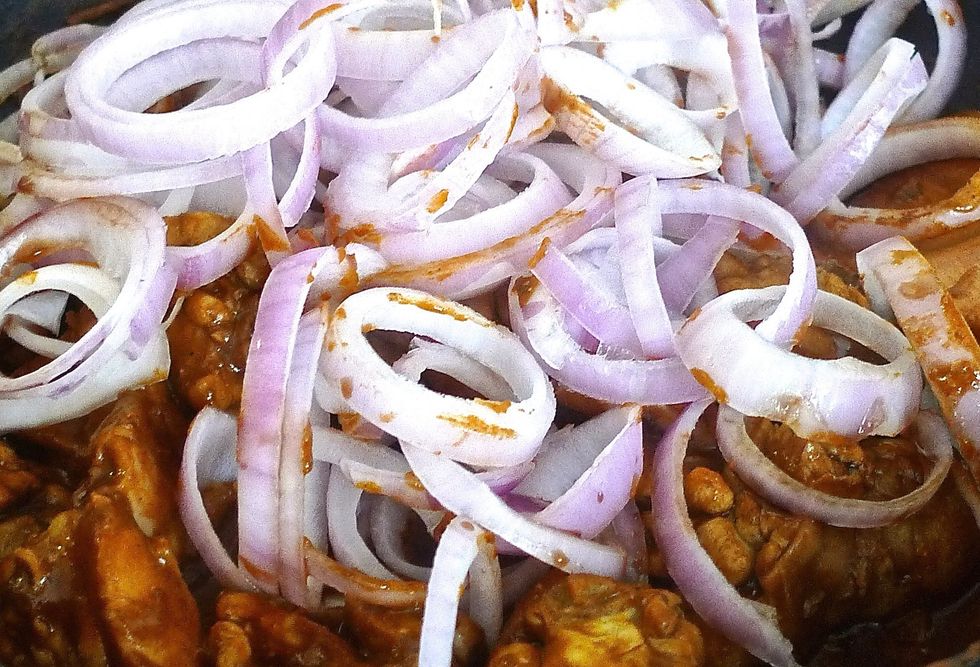 Add the cut onion rings into the chicken mixture.