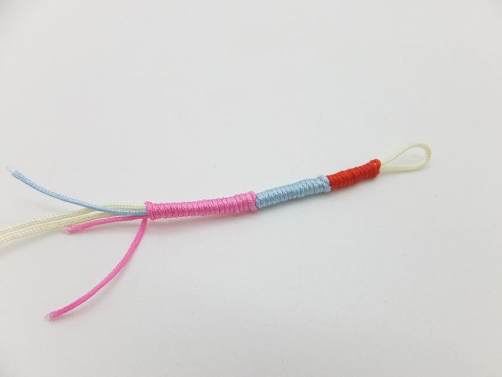 Add the different color cord and continue wrapping the working end.