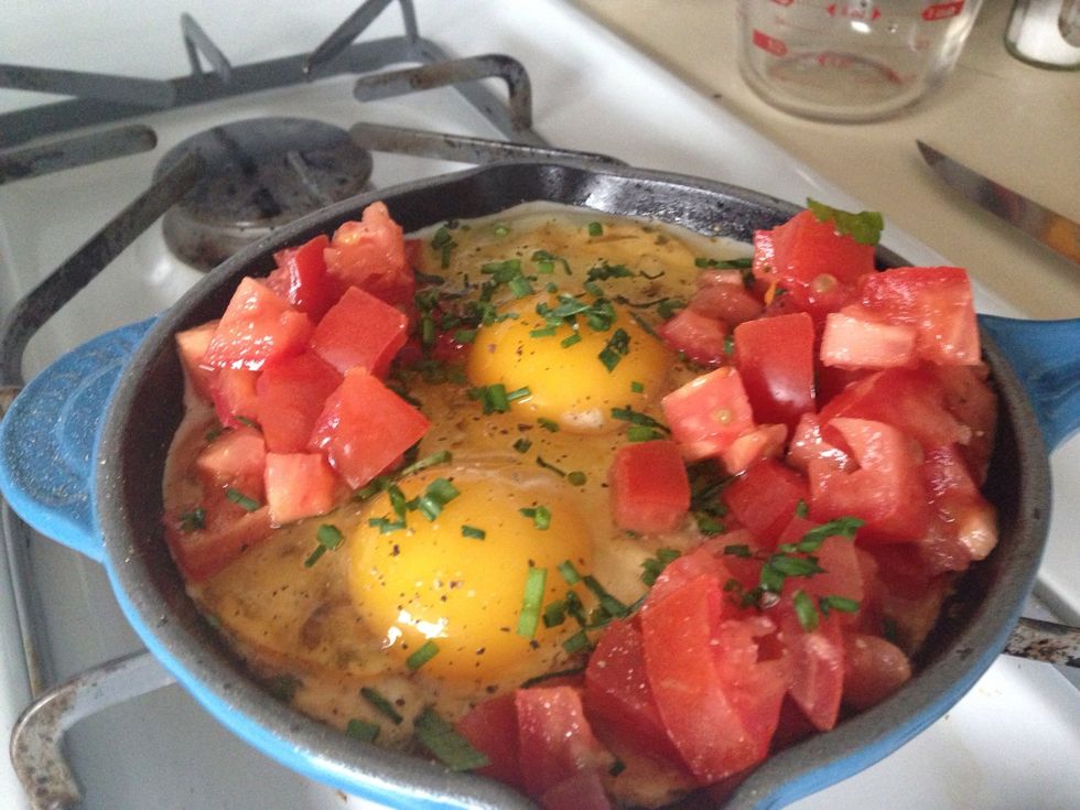 Add the eggs, tomato, 1tbsp chives, salt, and pepper to the skillet, on top of the yogurt.