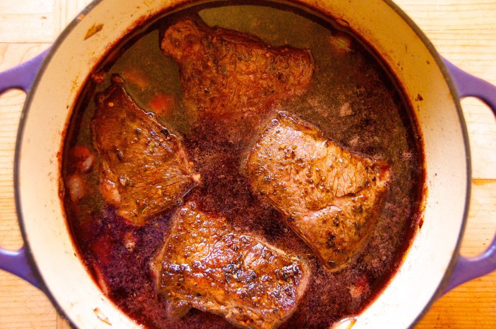 Add the entire bottle of wine, the broth and put the ribs back in the pot. Bring to a boil, then reduce heat to medium and cook down the wine by 50% - about 25 minutes. Place in oven for 2.5 hours.