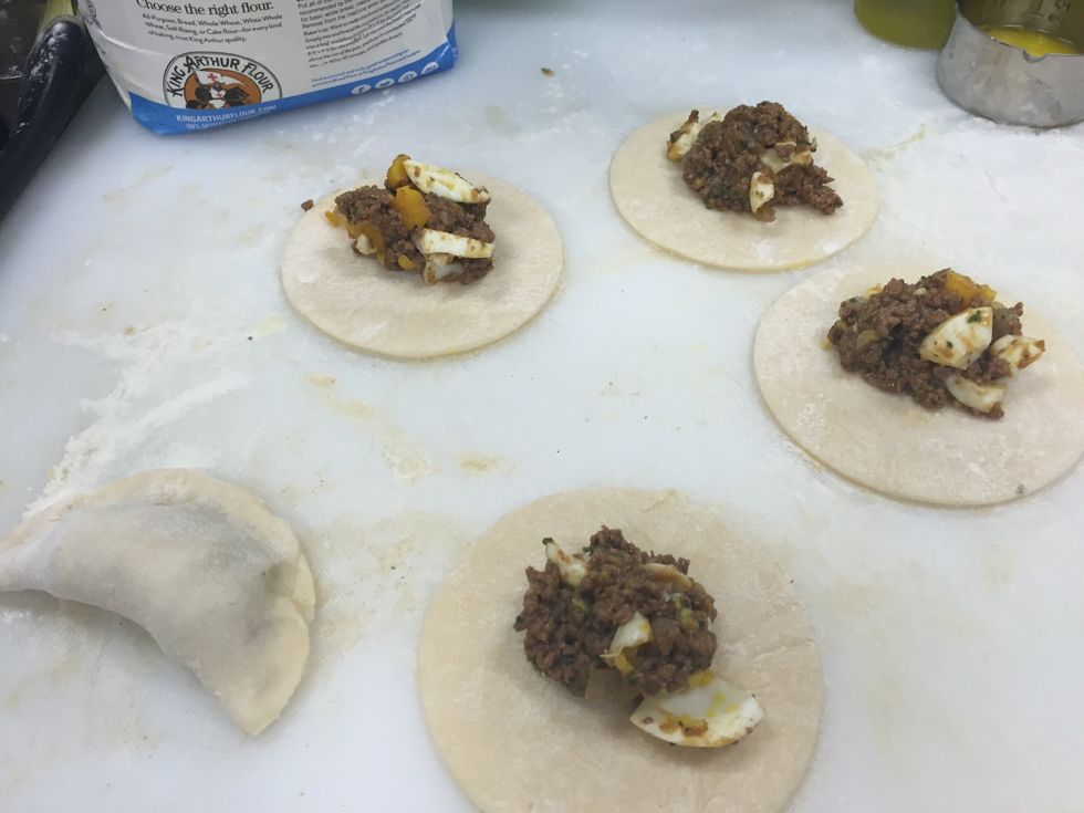 Add the feeling, before closing add some water on the corners to help seal the empanadas