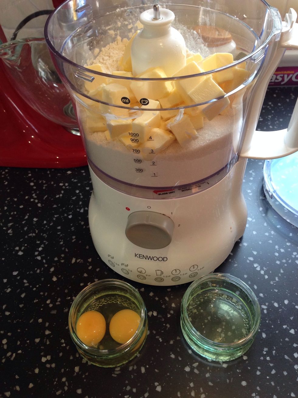 Add the flour, sugar and butter to a good processor. Turn on and gradually add 2 egg yolks and one egg white. Reserve the remaining egg white for later.