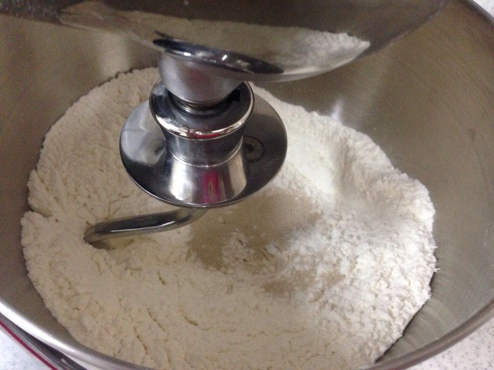 Add the flour , sugar, salt and yeast together and mix them well .
