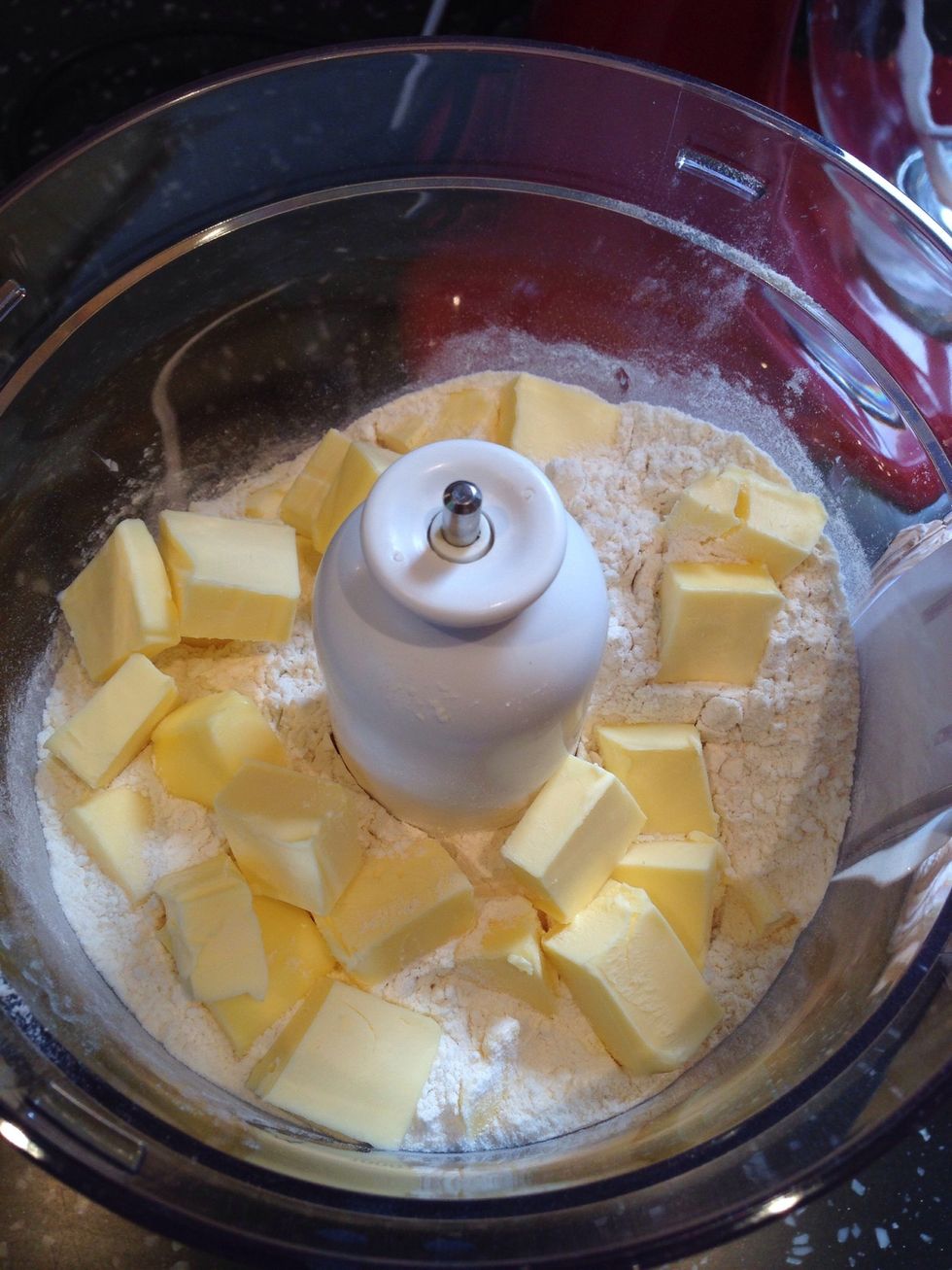 Add the flours and butter the a food processor and pulse a few times