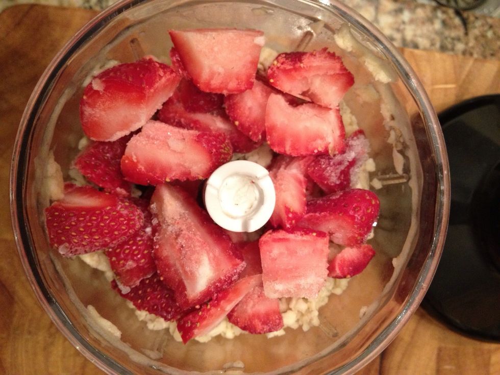 Add the frozen sliced strawberries. Process