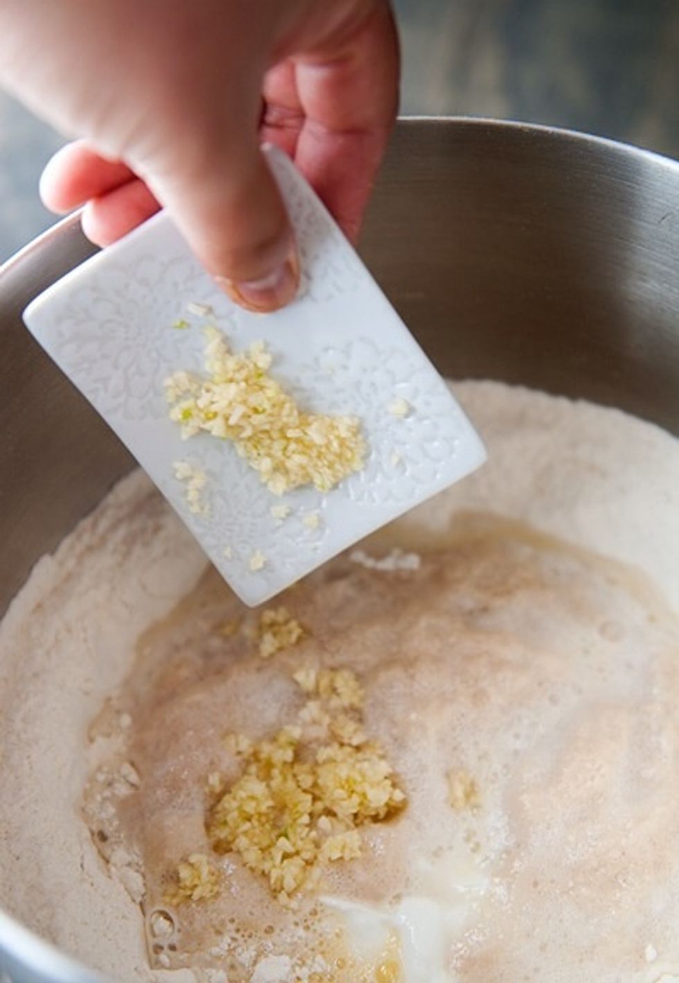 Add the garlic, yeast mixture, milk, yogurt, egg, oil, and water into the dry mix that we mixed at the start.