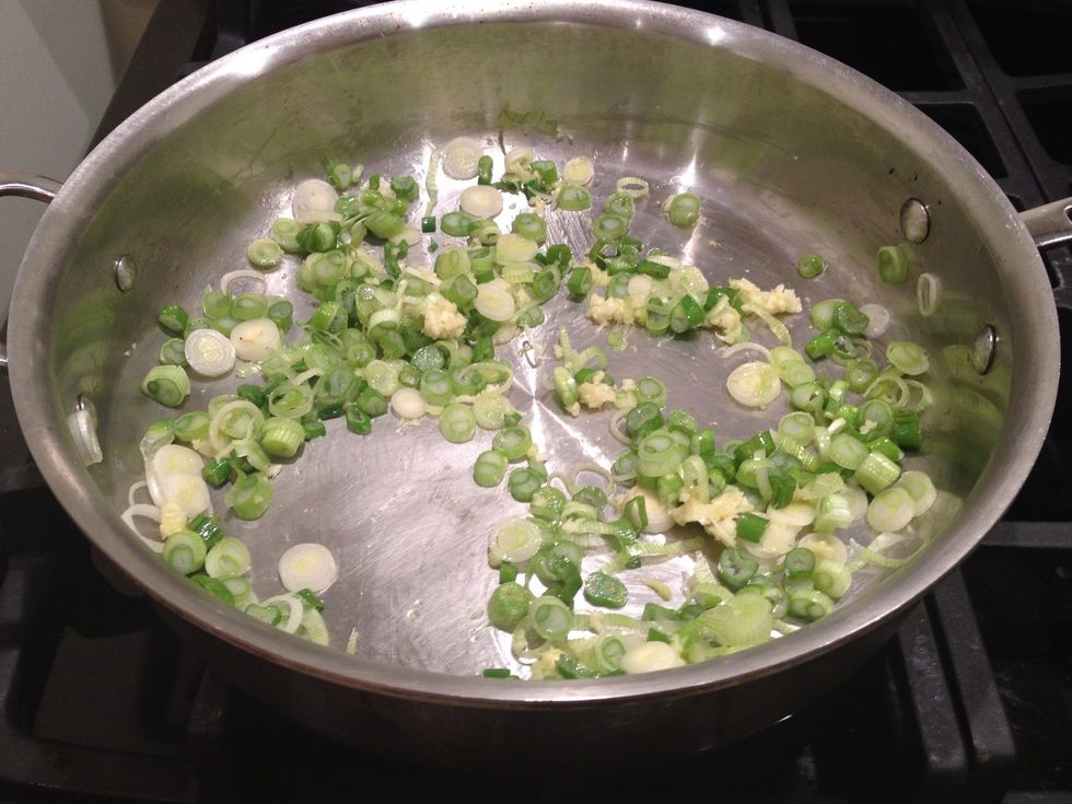 Add the green onions and the minced garlic cloves. Saut\u00e9 for a minute or two, continuously stirring.