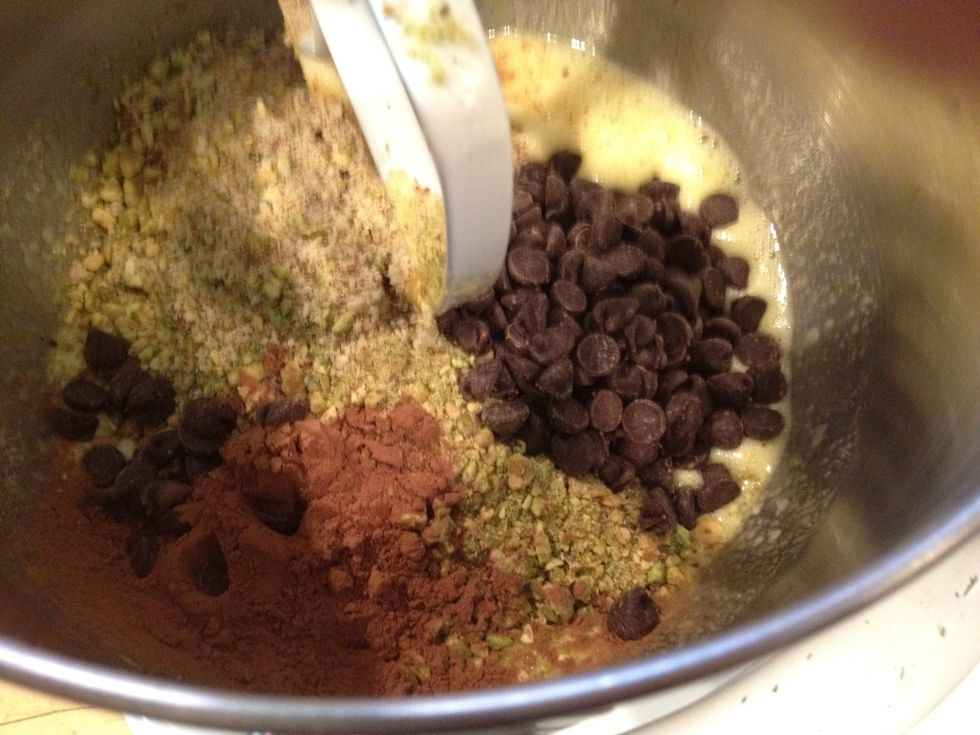 Add the ground pistachios and almonds, 1 tablespoon cocoa powder, and 3/4 cup chocolate chips.