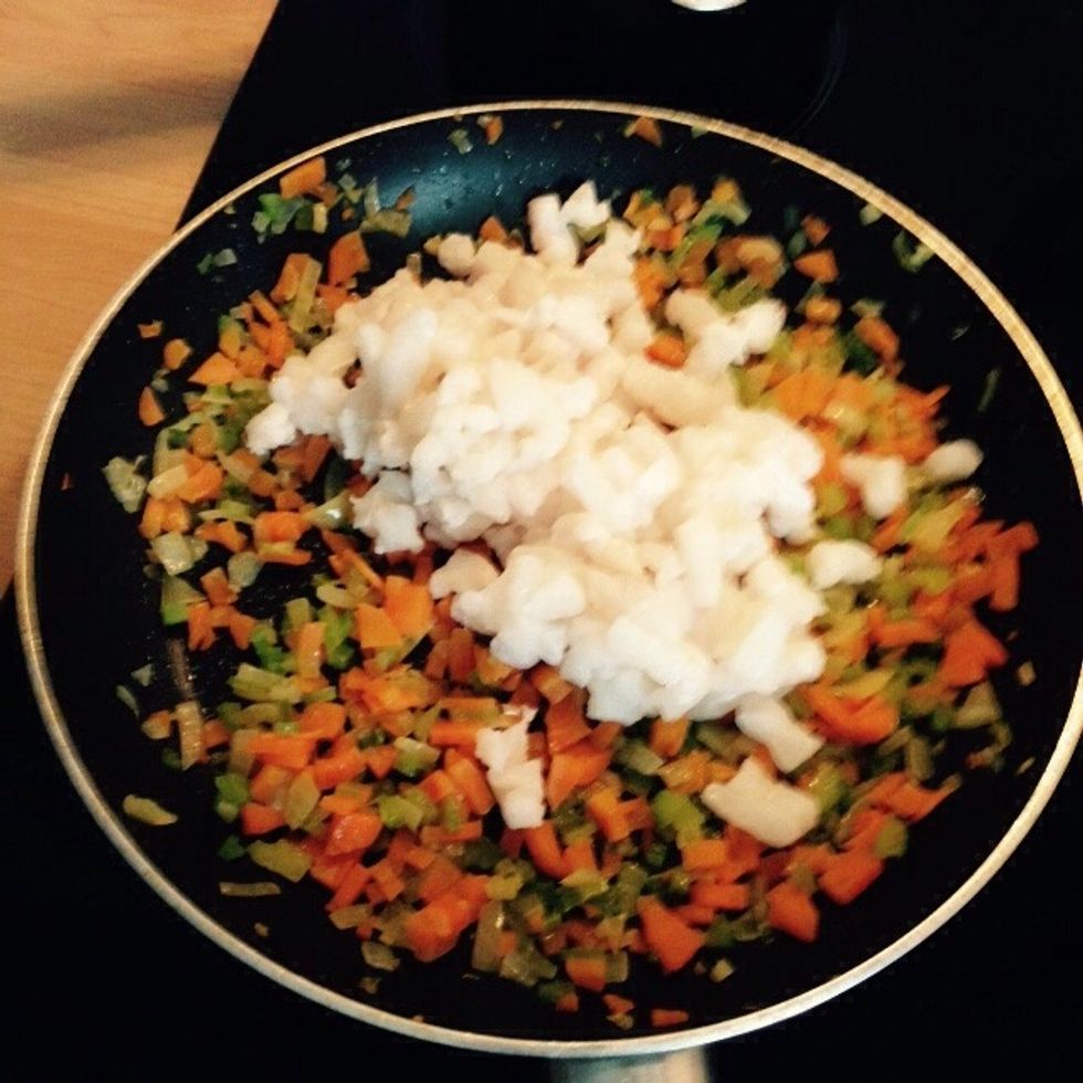 Add the halibut to the soffritto and saut\u00e9 it. Avoid using a spoon as much as possible to avoid spoiling the tender flesh of the fish.
