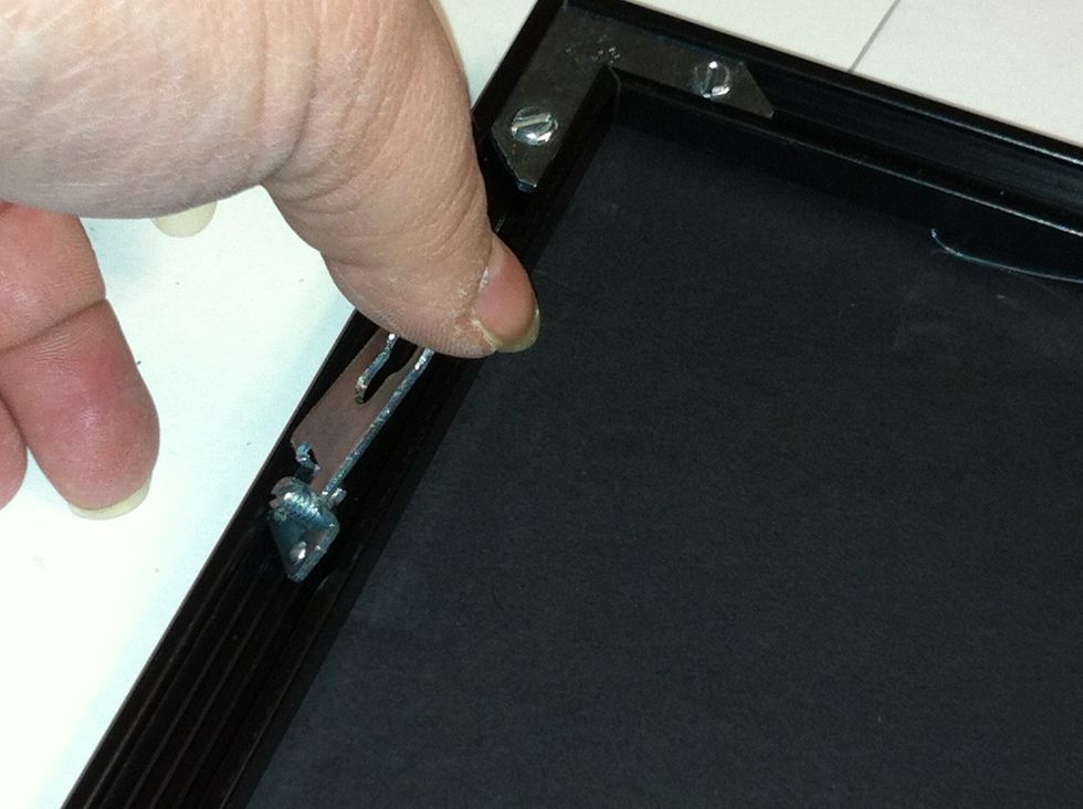 Add the hanging devices. The will slip into the channel with the hole pointing toward the middle of the picture. They are hung about 1/4 of the way down the side.