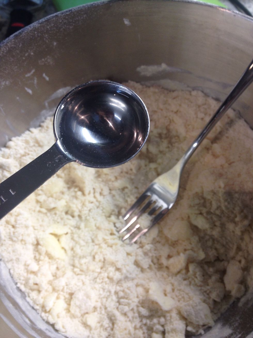 Add the ice-water one tablespoon at a time and mix with a fork. The ice water will work to bind the mixture and form the pie dough.