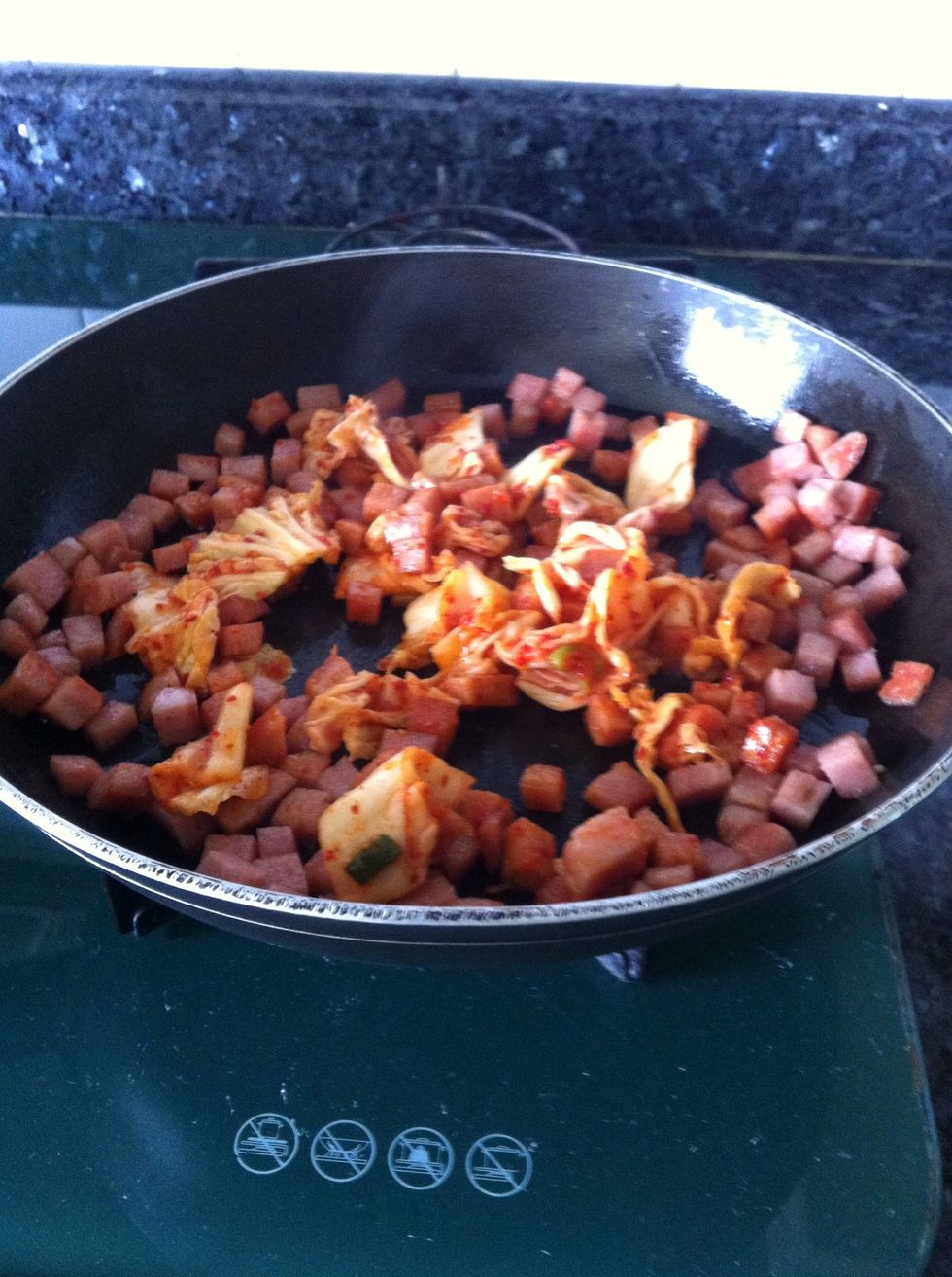 Add the Kimchi without the sauce. Keep the sauce for the later part of the cooking.