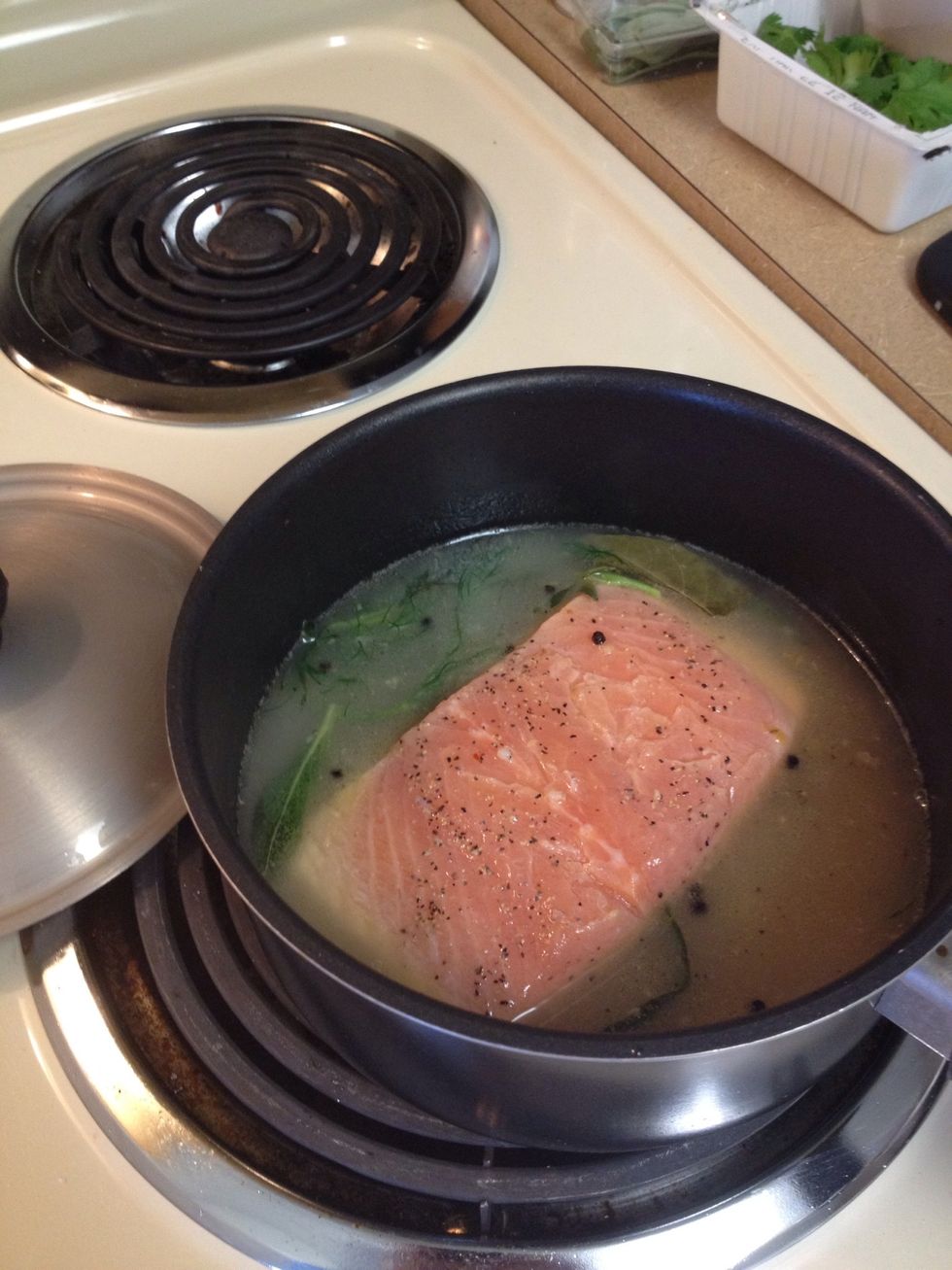 Add the liquid and bring to simmer. Season the salmon with salt and pepper and add it to the poaching liquid.