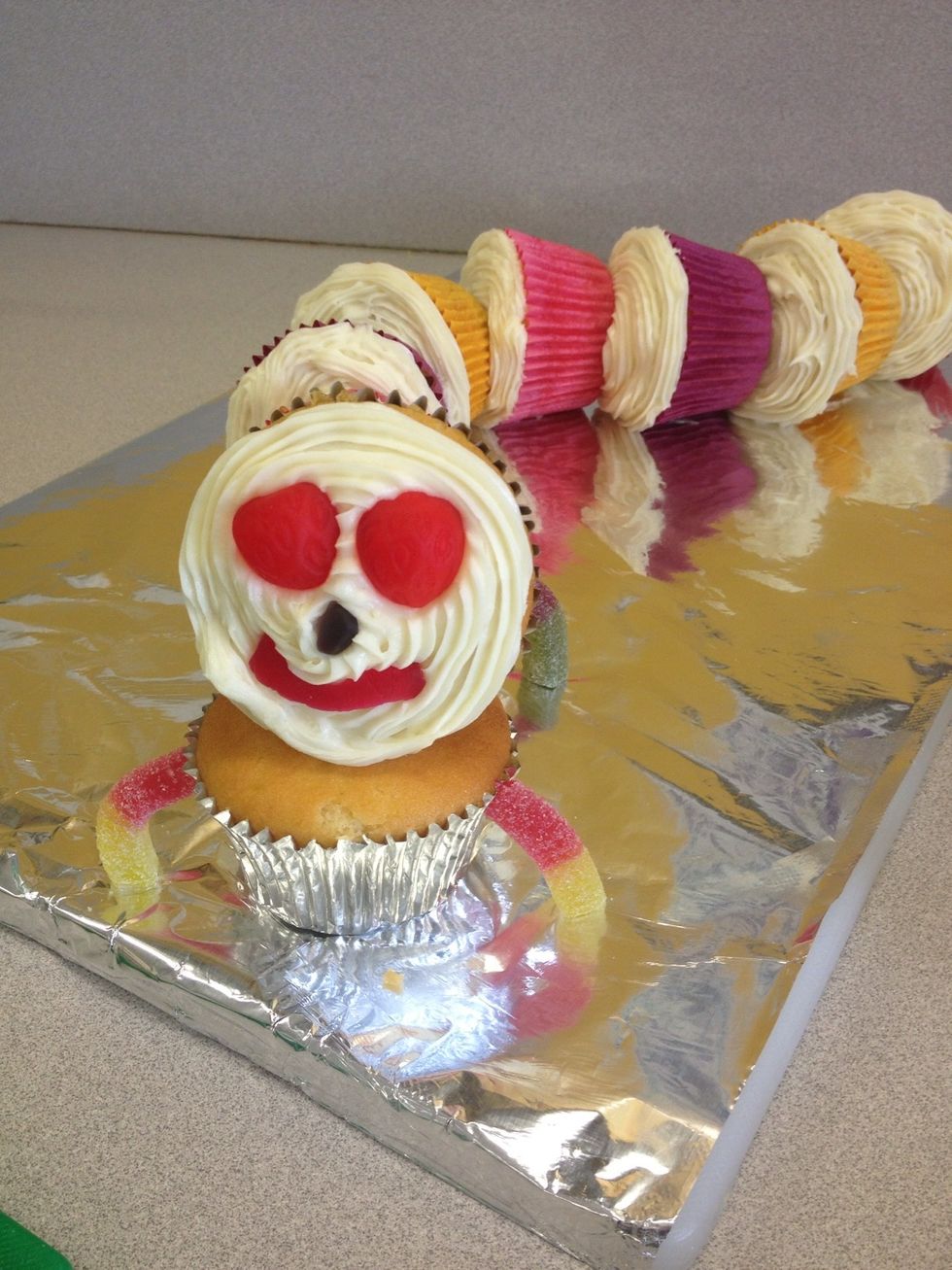 Add the lollies for the face and begin to put all the sour worms on as the legs.