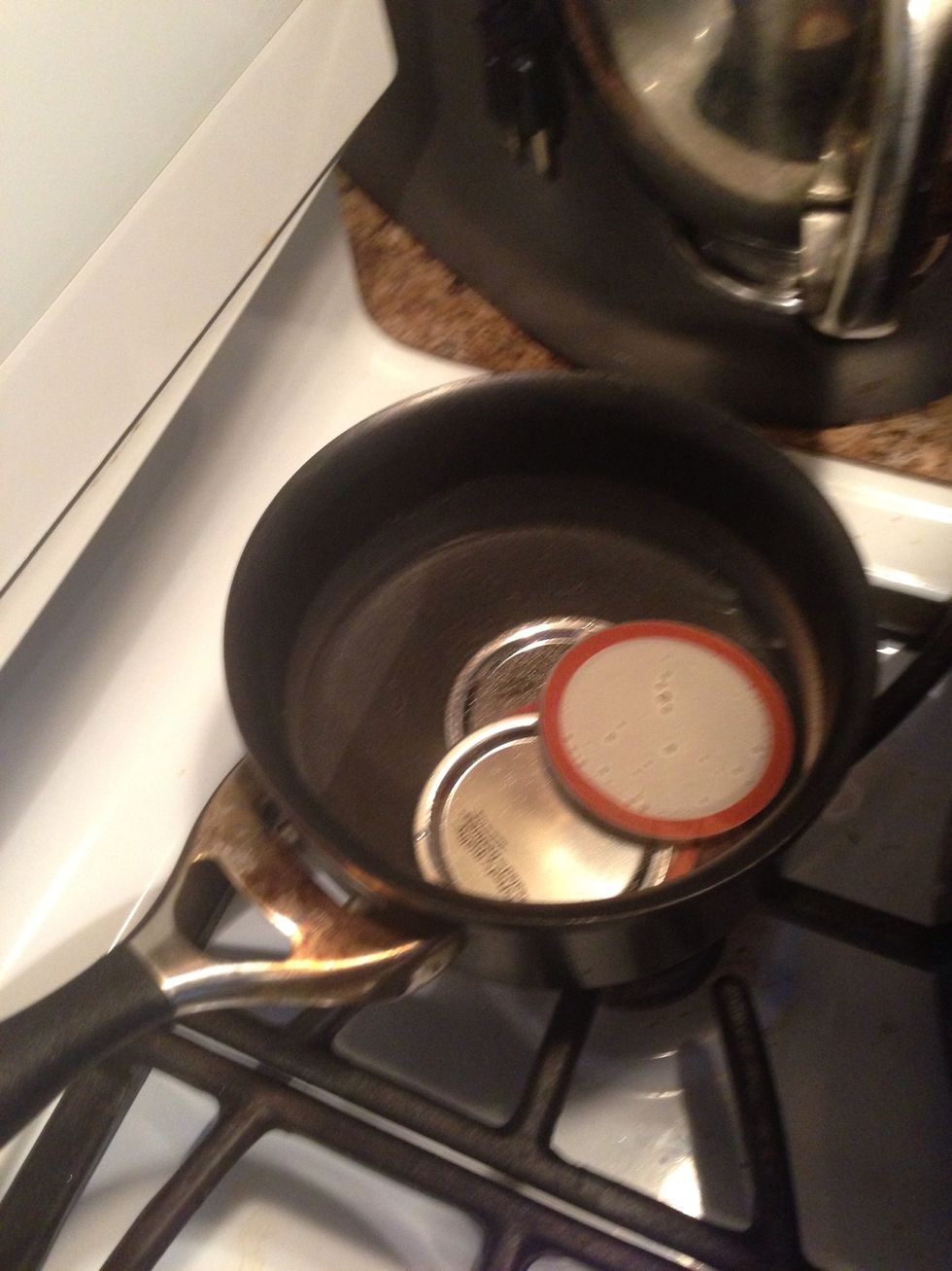 Add the mason jar kids to water in a small pot and put it on low. You want to heat them, but not boil. This softens the rubber seal around the edge.