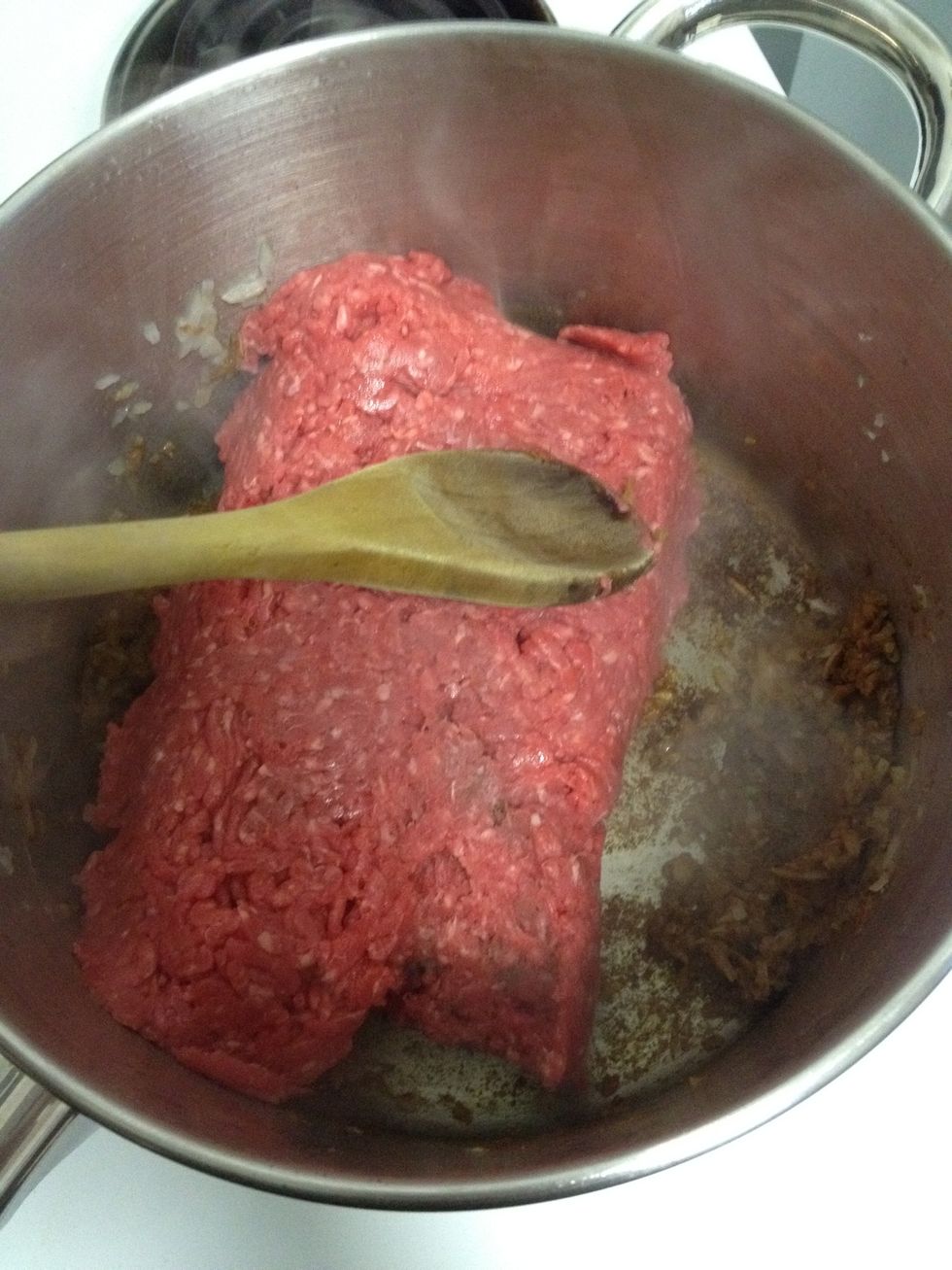 Add the meat and combine together using a wooden spoon breaking all the clumps. After 2 minutes of cooking the meat, turn the stove to high, to brown the meat and continue cooking and breaking clumps