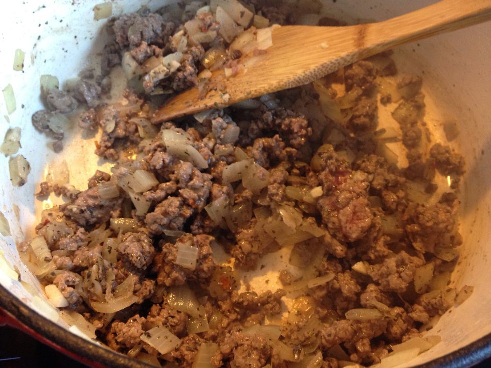Add the meat and garlic to your pot, on high heat. If you're using dried herbs, add them once the meat has browned. I've got a fair bit of oregano, basil, cinnamon and even a pinch of chilli in there.