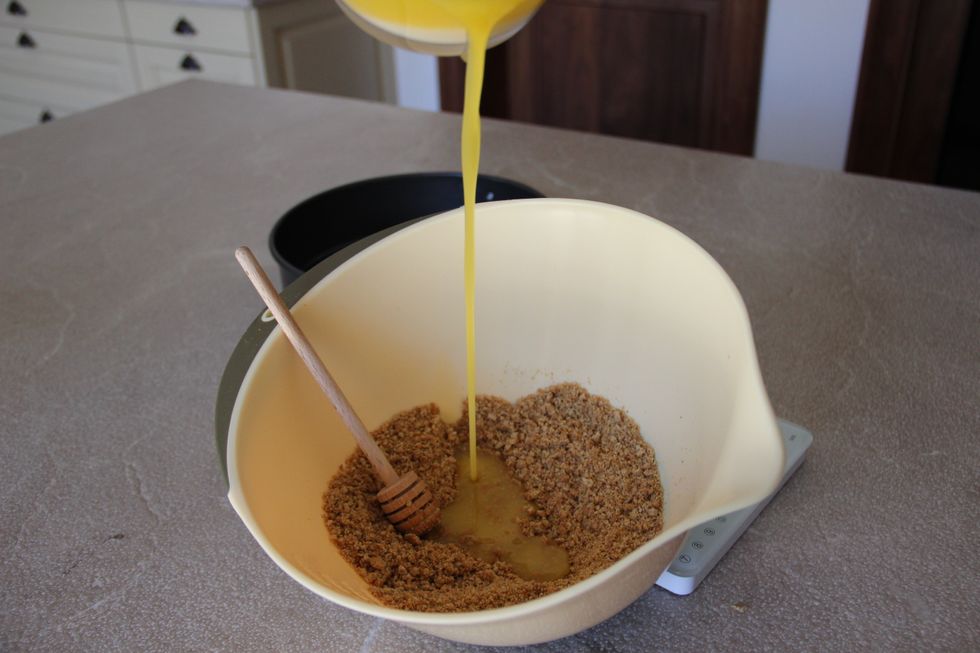 Add the melted butter into the biscuits and stir together